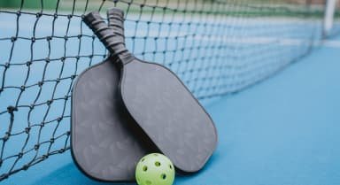 two pickle ball racquets with a yellow ball